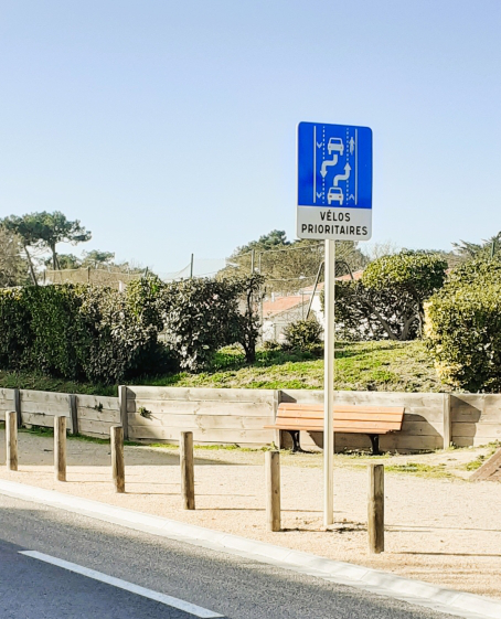 Panneau de ville montrant la règle de priorité pour les vélos avec la piste cyclable en dessous