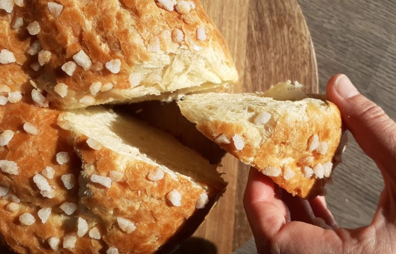 pastis-landais Une spécialité pâtissière des Landes le pastis landais avec une main qui prend une part sur un marché